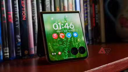 The Moto Razr Ultra with its cover display on resting on a bookcase.